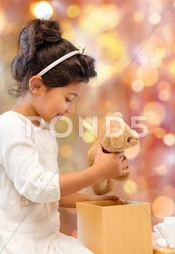 Happy little girl with gift box and teddy bear Stock Photos