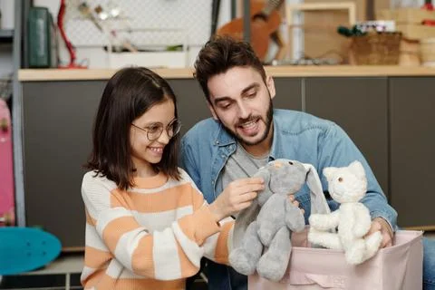 Happy little girl with grey soft toy rabbit and her father with white teddybear Stock Photos