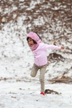 Happy little girl jumping on snow Stock Photos
