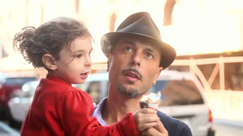 A happy little girl kisses her dad's cheek after eating some ice-cream Stock Footage