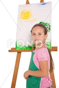 Happy little girl painting on easel Stock Photos