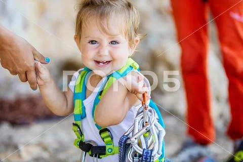 Happy little girl playing with rock climbing equipment Stock Photos