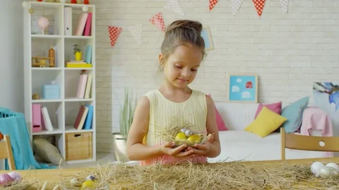Happy Little Girl Posing with Easter Eggs in Hay Nest Stock Footage 106067153