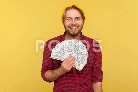 Happy lottery winner, rich hipster guy in beanie hat and checkered shirt hold Stock Photos