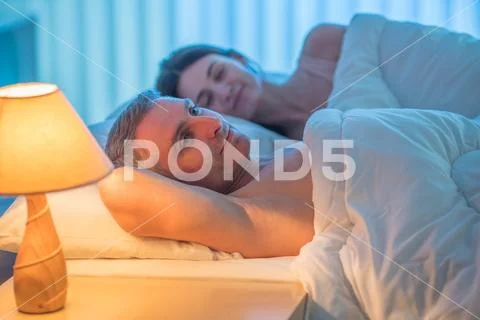 The happy lovers lay on the bed. Evening night time Stock Photos