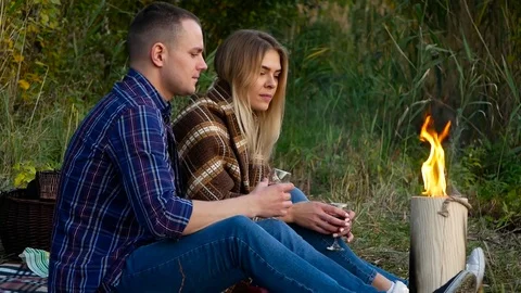 Happy lovers near the fire drinks wine Stock Footage 82214005