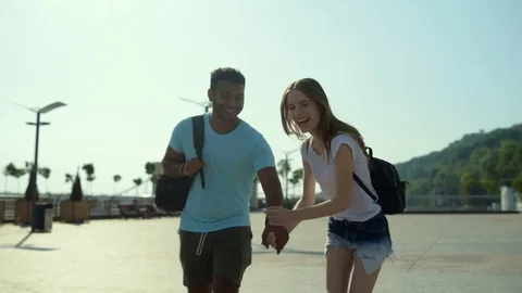 Happy lovers running against urban background Stock Footage