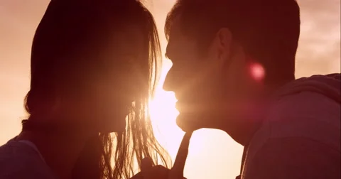 Happy loving couple kissing at sunset showing emotional intimacy touching Stock Footage