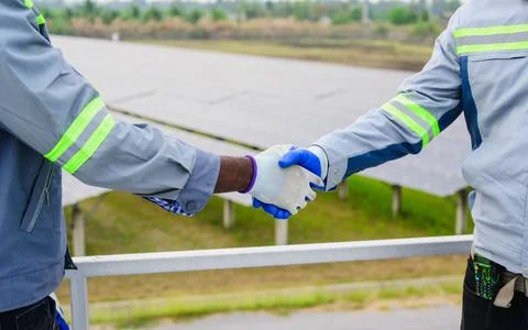 Happy maintenance engineer checking and maintaining solar panels system Stock Photos