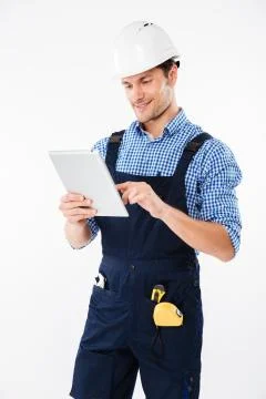 Happy male builder using pc tablet isolated 写真素材