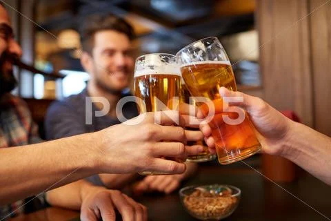 Happy male friends drinking beer at bar or pub Stock Photos