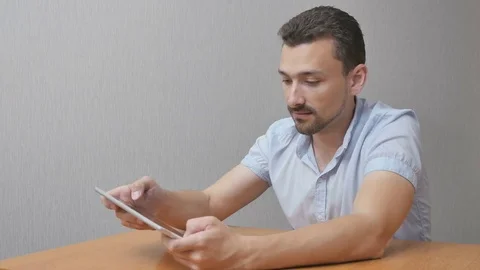 The happy man in amazement uses a tablet Stock Footage 76995648