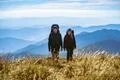 The happy man and a woman with backpacks walking to the mountain Photo
