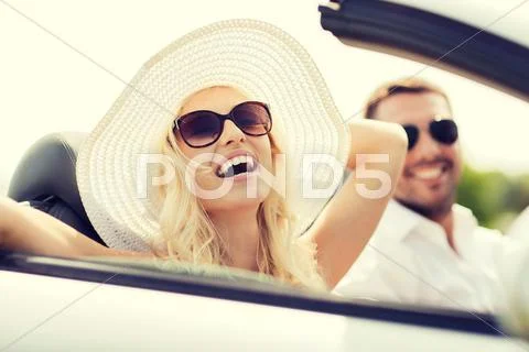 Happy man and woman driving in cabriolet car Stock Photos