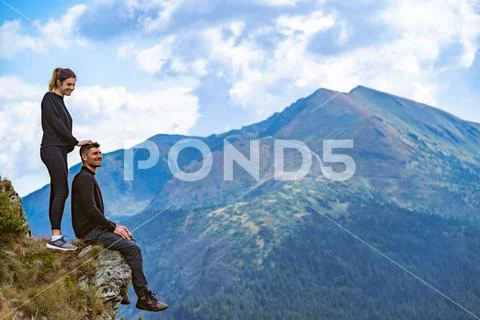 The happy man and a woman enjoying on the beautiful cliff Stock Photos