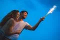 The happy man and woman hold a firework stick. evening night time Photo