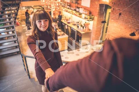 The happy man and a woman hold hands in the restaurant Stock Photos