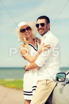 Happy man and woman hugging near car at sea Stock Photos