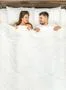 The happy man and woman lay on the bed. View from above Photo