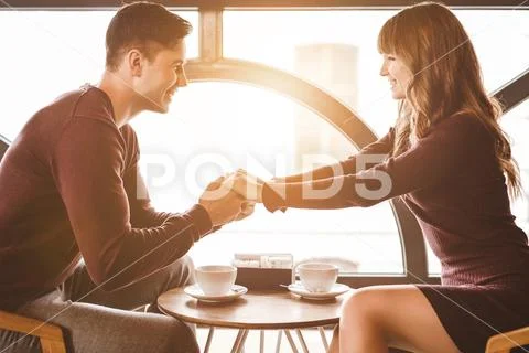 The happy man and a woman sit at the restaurant table Stock Photos