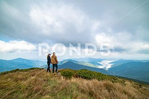The happy man and a woman standing on the top of a mountain Stock Photos