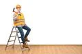 The happy man with the ax standing on the ladder on the white wall background Photo