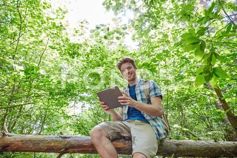 Happy Man With Backpack And Tablet Pc In Woods