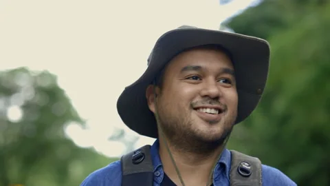 Happy man with a backpack is walking alone the road. Man is looking forward. Stock Footage 158787500