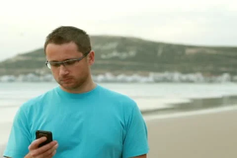 Happy man on the beach talking on mobile phone Stock Footage 10791469