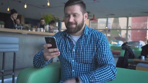 Happy man browsing smartphone in cafe, portrait, steadicam shot  動画素材 72946909