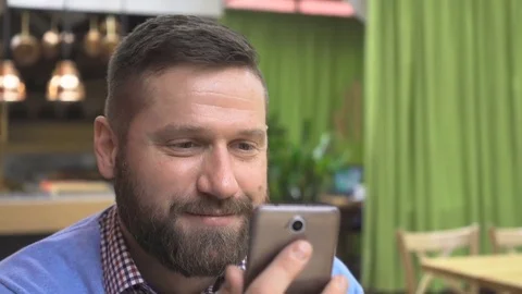 Happy man browsing smartphone, portrait, in pub, cafe, indoor, close steadicam Vídeo Stock 73067301