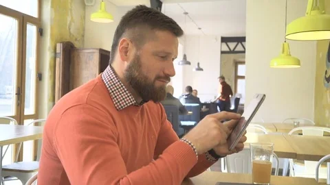 Happy man browsing tablet computer, smiling at camera, profile, cafe, steadicam Video stock 73266656