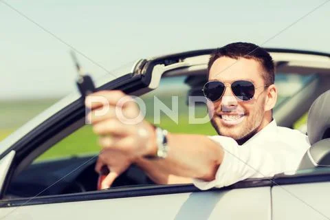 Happy man in cabriolet showing car key Stock Photos
