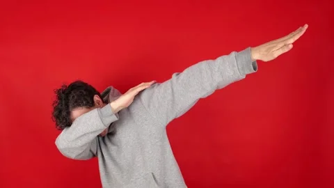 Happy man in casual making dab arms gesture on blank red studio background Видео 304746033