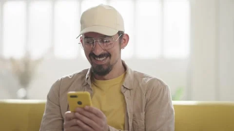 Happy Man celebrating mobile win uses Phone at home. Man reading good news Video stock 272754400