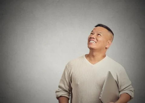 Happy man with computer thinking looking up Stock Photos