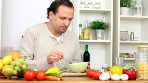 Happy man cooking in the kitchen Stock Footage 8983519