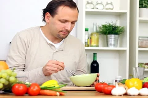 Happy man cooking in the kitchen Stock Footage 8983520