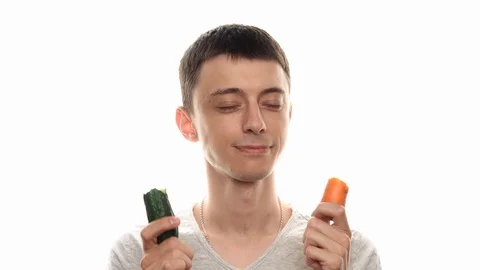 Happy man dancing and eat vegetables at studio with white background Stock Footage 112769327