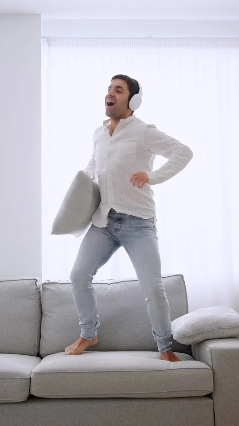 Happy man dancing on sofa. Stock Footage 262918020