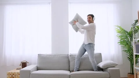 Happy man dancing on sofa. Stock Footage 263597879
