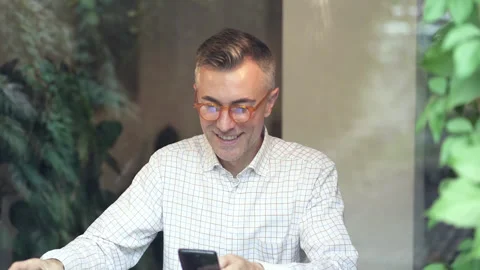 Happy man drinking coffe from white cup and holding mobile phone. Stock Footage 141259818