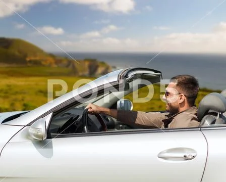 Happy man driving convertible car Stock Photos