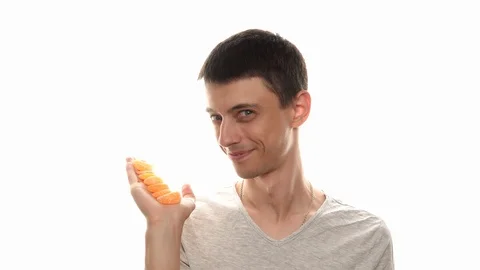 Happy man eats mandarin Stock Footage