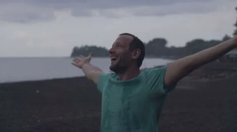 Happy man enjoying rain on the beach, super slow motion, 240fps HD Stock Footage