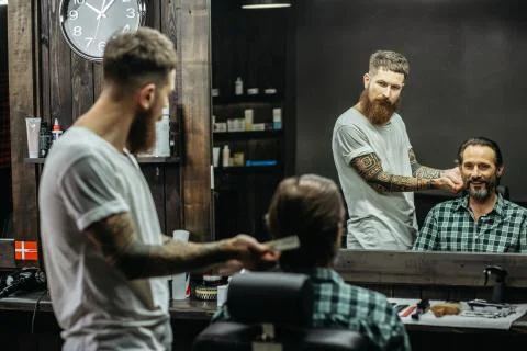 Happy man feeling satisfied while looking at the haircut Stock Photos