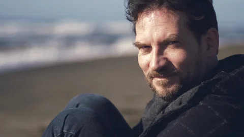 Happy man in front of the ocean after quarantine for coronavirus showing thum Stock Footage 129518793
