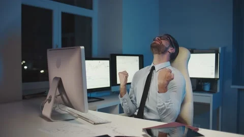 Happy man gesturing and looking at computer while staying late in the office Stock Footage 160899449