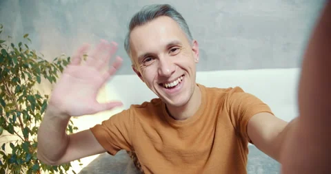Happy man gesturing showing a thumbs up and emotionally talking online at home Stock Footage 133107222