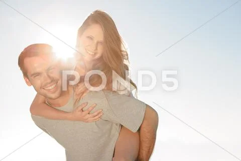 Happy Man Giving A Piggy Back To His Girlfriend